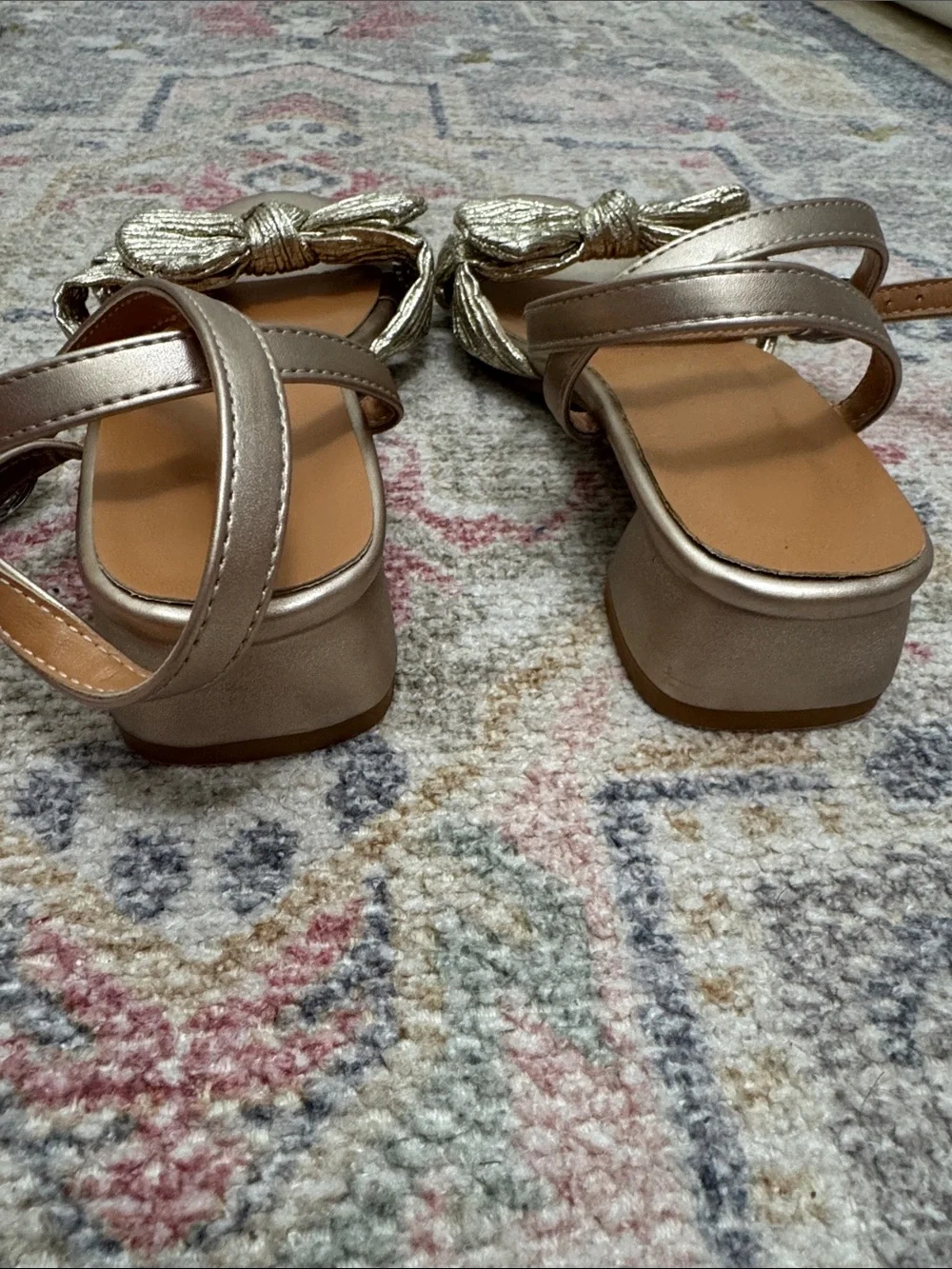 Girls gold ankle wrap sandals with bow.